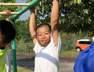 うんていにぶら下がる男の子