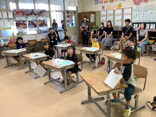 見つけたことを話そうと手を挙げるこどもたち