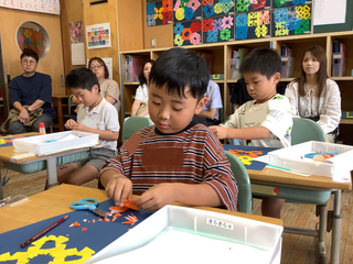 折り紙を開いてみようとする男の子