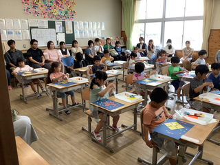 折り紙にシールで飾り付けするこどもたち