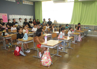 先生の話を聞くこどもたち